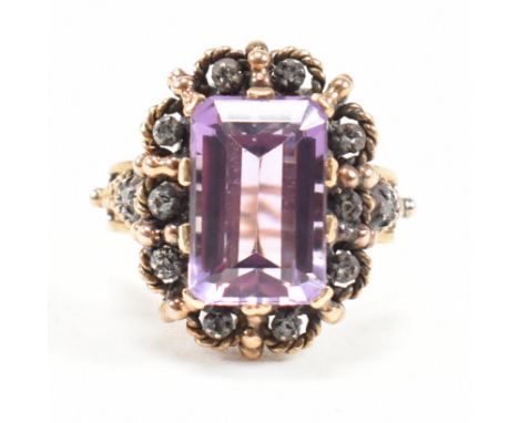 Continental 18ct gold amethyst and diamond dress ring. The ring set with a large step cut amethyst framed by silver collet se