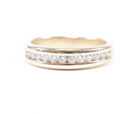 A hallmarked 9ct gold and diamond half eternity ring. The ring set with twelve suspension set round brilliant cut diamonds to