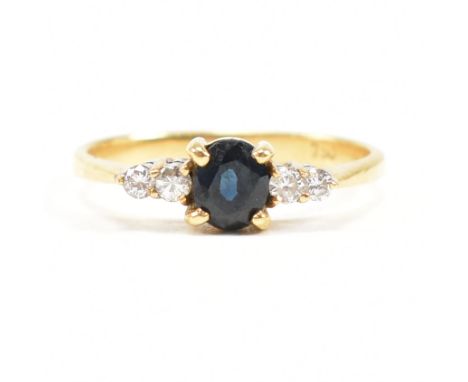 A gold sapphire and diamond five stone ring. The ring set with a central sapphire flanked by four diamonds. Stamped 18ct. Wei