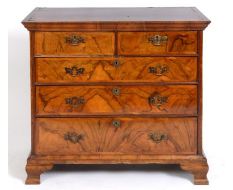 A chest, veneered in walnut, having two short and three graduated long drawers, on ogee bracket feet, 101.5 cm wide  See illu
