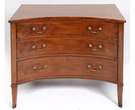 An unusual George III concave fronted mahogany chest, of three long drawers, with boxwood stringing, on splay front feet, the