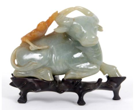 A carved jade group, of a boy on a buffalo's back, on a hardwood stand, 10.5 cm high  See illustration Condition report Repor