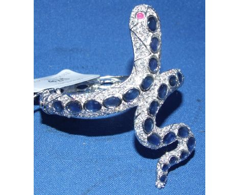 A silver, sapphire and white stone bangle, in the form of a serpent, with ruby eyes