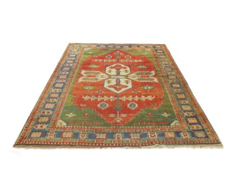Persian carpet, on red ground with green floral border, 115" x 92" approx