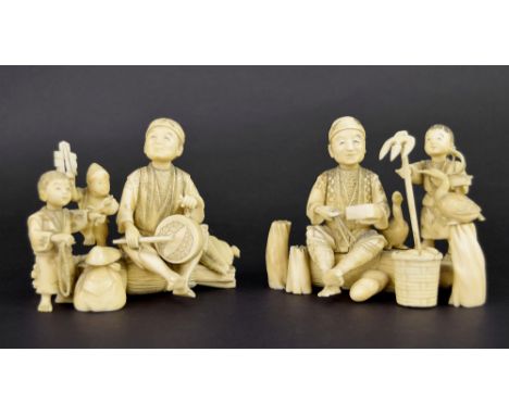 Pair of Japanese ivory okimono sectional groups, one modelled as a father and son playing a daruma drum with a performing mon