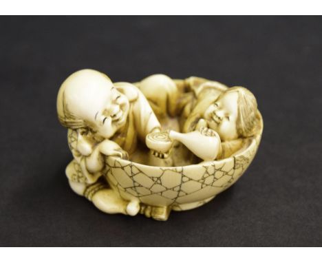 Japanese ivory netsuke, modelled with a lady and gentleman in a circular tub sharing a drink, signed, Meiji period,  2.5" wid