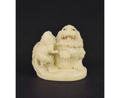 Japanese carved ivory, modelled with mystical beasts upon an oval base, 2" high