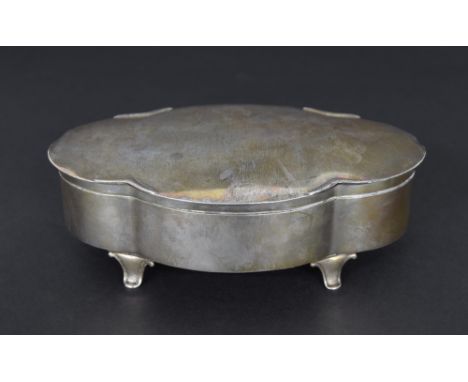 Early 20th century oval silver trinket box and hinged cover of lobed form with a silver-gilt interior upon four short splayed