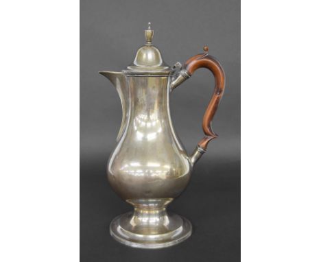 George III silver ewer, of baluster form with a hinged cover surmounted with an urn finial, scroll handle raised on a circula