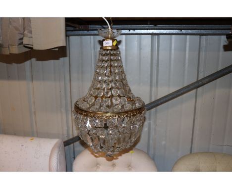 A glass and brass rise and fall pendant light fitting with prism drops 