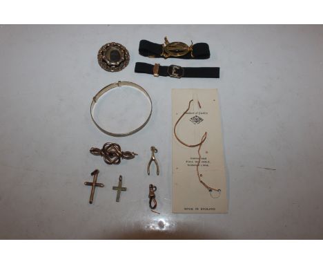 A 9ct gold bangle with metal core; a rolled gold brooch set with red stone; a yellow metal memorial brooch; two cross pendant