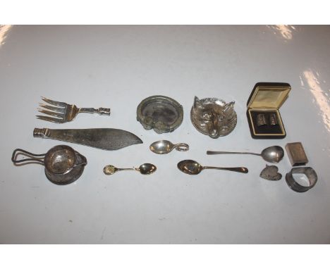 A silver strainer and stand; a silver napkin ring; a silver heart shaped name place holder; a silver match box cover; two sil