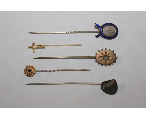 A yellow metal and blue enamel decorated stick pin; a 15ct gold stick pin set with coloured stone; and three other stick pins