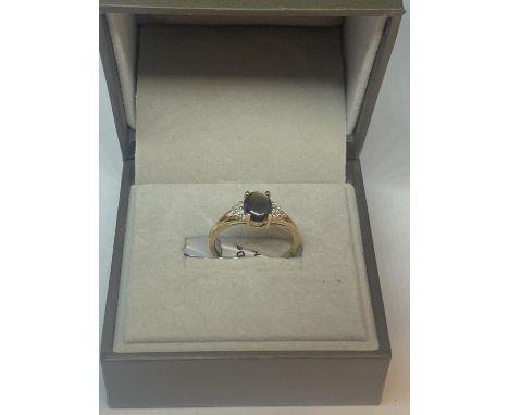 A 9 CARAT GOLD RING MARKED 375 WITH A CENTRAL SMOKEY QUARTZ STYLE STONE AND THREE CLEAR STONES ON EACH SHOULDER SIZE O GROSS 