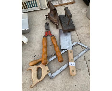 AN ASSORTMENT OF TOOLS TO INCLUDE TWO VINTAGE FLAT IRONS, A MEAT CLEAVER AND A HACKSAW ETC 