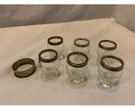 SIX SHOT GLASSES WITH HALLMARKED BIRMINGHAM SILVER RIMS AND A NAPKIN RING 