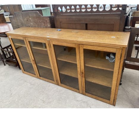 AN EARLY 20TH CENTURY LIGHT OAK FOUR DOOR GLAZED BOOKCASE, 73" WIDE BEARING LABEL HENSHAWS WORKSHOPS FOR THE BLIND, OLD TRAFF