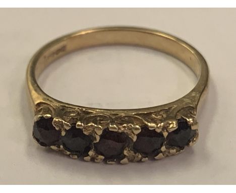 A 9 CARAT GOLD RING WITH FIVE IN LINE RED STONES POSSIBLY RUBIES SIZE K/L 