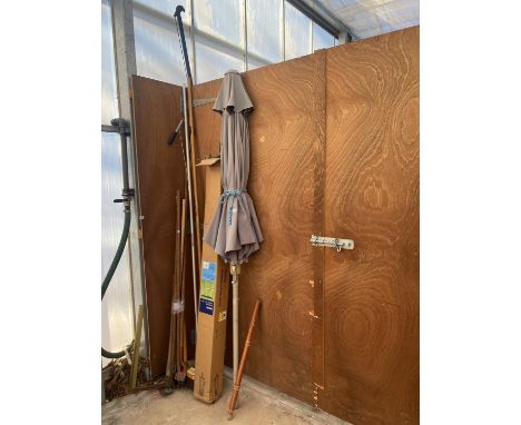 AN ASSORTMENT OF GARDEN ITEMS AND TOOLS TO INCLUDE TWO PARASOLS AND A PICK AXE ETC 