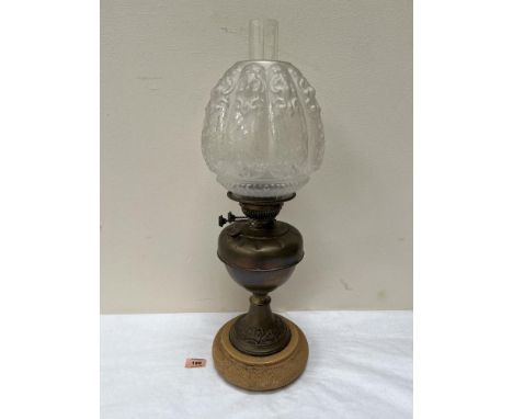 A brass oil lamp with moulded etched shade