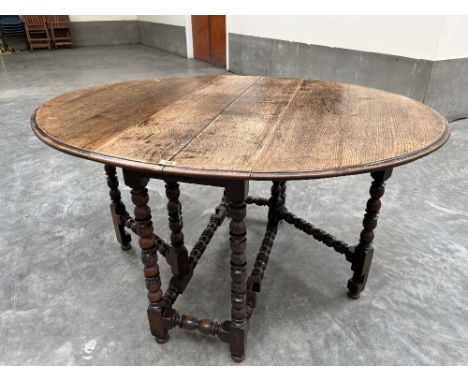 An antique joined oak dropleaf table on bobbin turned legs and perimeter stretchers. 44' wide