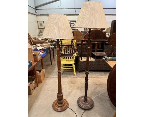 Two oak lamp standards with cream pleated shades