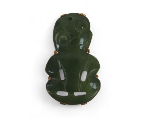 A New Zealand Maori Hei-tiki carved jade pendant in a gold brooch/pendant mount, tests to 18ct marked 8K, 25mm by 45mm, 9.5gs