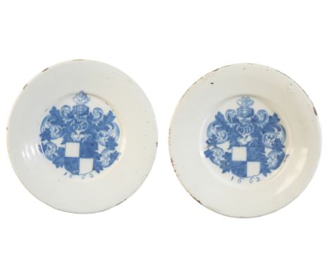 A PAIR OF ENGLISH DELFTWARE ARMORIAL PLATES decorated in blue with a coat of arms within a leafy mantling and dated 1662, 21.