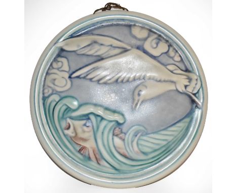 A Pilkington's Royal Lancastrian circular wall plaque, designed by William S Mycock, decorated with a fish leaping in the wav