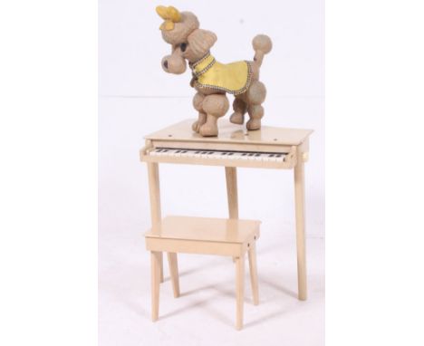 A vintage 1950's childs piano and stool in original finish together with a bendy composite dog. H41 W41 D36cm