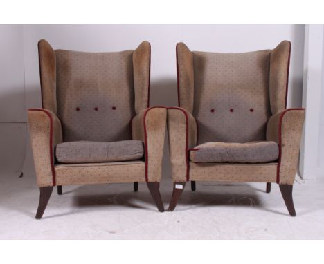 A pair of 1950's vintage retro wing back armchairs. Raised on tapered supports having the original moquette fabric with piped