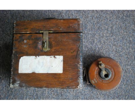 An early 20th century oak cased racing pigeon clock along with a vintage Air Ministry stamped 1939 Rabone leather cased tape 