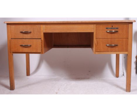 A 1950's air ministry style oak office writing table desk with central kneehole recess flanked by drawers to either side.