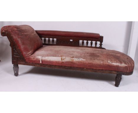 A Victorian oak and faux leather chaise longue sofa day bed raised on turned legs with spindle back rail in shabby chic uphol