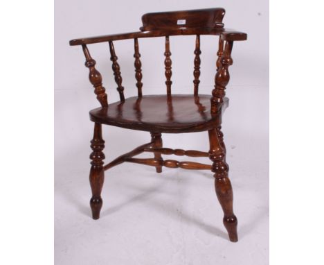 A Victorian 19th century beech and elm smokers bow / windsor armchair. Raised on turned legs with bobbin turned peripheral st