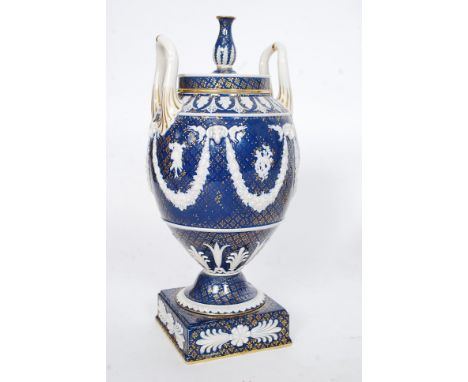 A 19th century Wedgwood urn having blue glaze with rams head, floral suspended swags having central motif of bow and quivers.