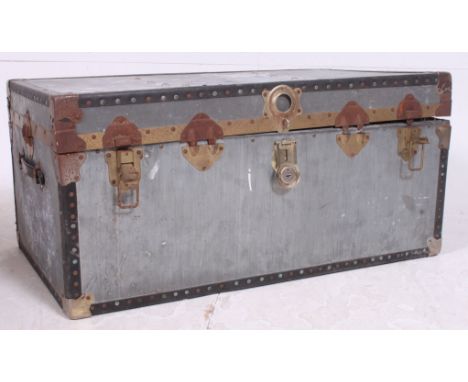 A vintage metal steamer trunk of usual form