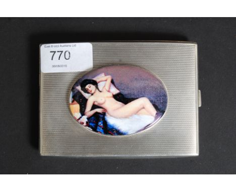 A hallmarked silver cigarette case, with applied ceramic enamel pictorial image of a nude lady.