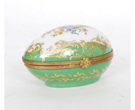 An early 20th century fine porcelain Le Tallec ceramic egg signed to the base. Decorated in green on white with brass banding