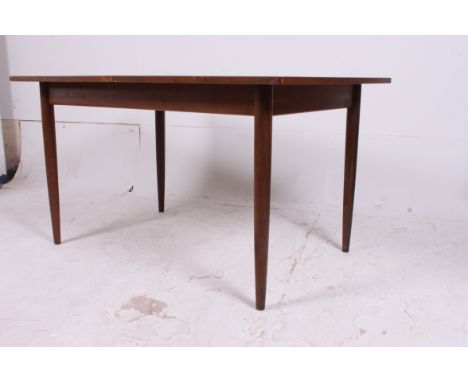 A 1970's  vintage retro mid century Scandart teak wood extending dining table raised on turned and tapered legs with extendin