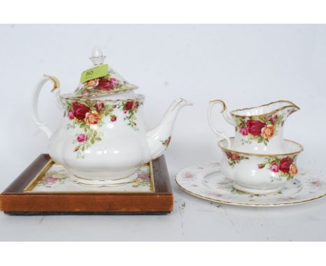 Royal Albert Country Roses tea pot, creamer, sugar bowl along with the Country Roses tea pot stand. Teapot 18cms high