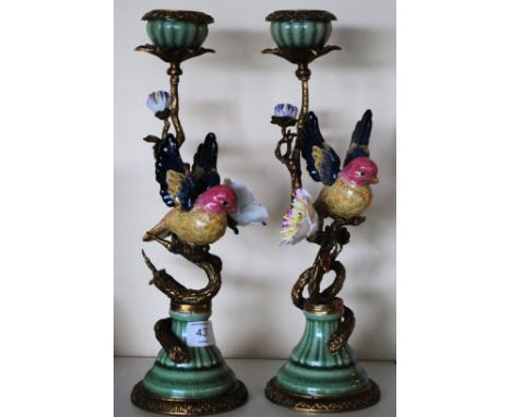 A pair of antique style ceramic candlesticks, decorated with tropical birds
