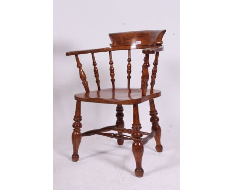 A Victorian 19th century beech and elm smokers bow / windsor armchair. Raised on turned legs with bobbin turned peripheral st