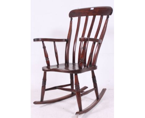 A Victorian beech wood rocking windsor chair having bow sleigh runners, turned legs with stretchers, saddle seat and lathe st