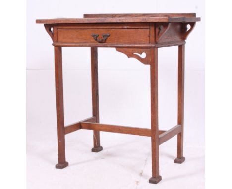 A Victorian Arts & Crafts oak side writing table desk in the manner of Liberty. The square tapered legs with lower tier havin