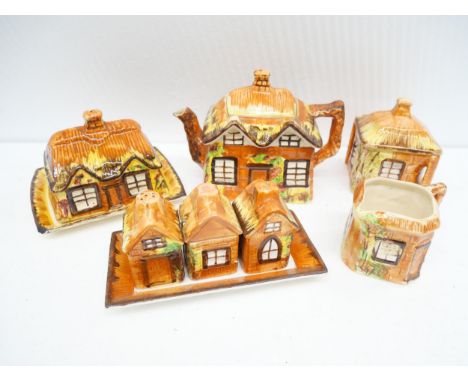 A collection of porcelain and china including cottage ware, novelty teapot, butter dish, creamer, sugar bowl, Devonware mug a
