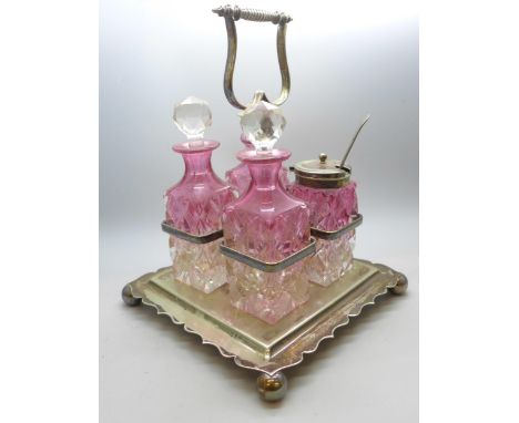 A cut glass four bottle cruet set in a silver plated stand 