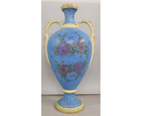 A ceramic twin handled vase with blue ground and floral transfer. Measuring approximately 39cm tall. 