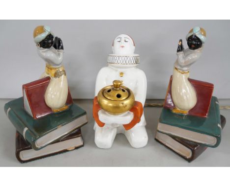 A pair of ceramic bookends in the form of blackamoor figures upon stacked books, both a/f. Together with a ceramic Art Deco p