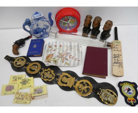 A box of assorted items including Harry Potter books, Glyn Colledge dish, Batman annual, carvings, horse brasses, parasol, Ca